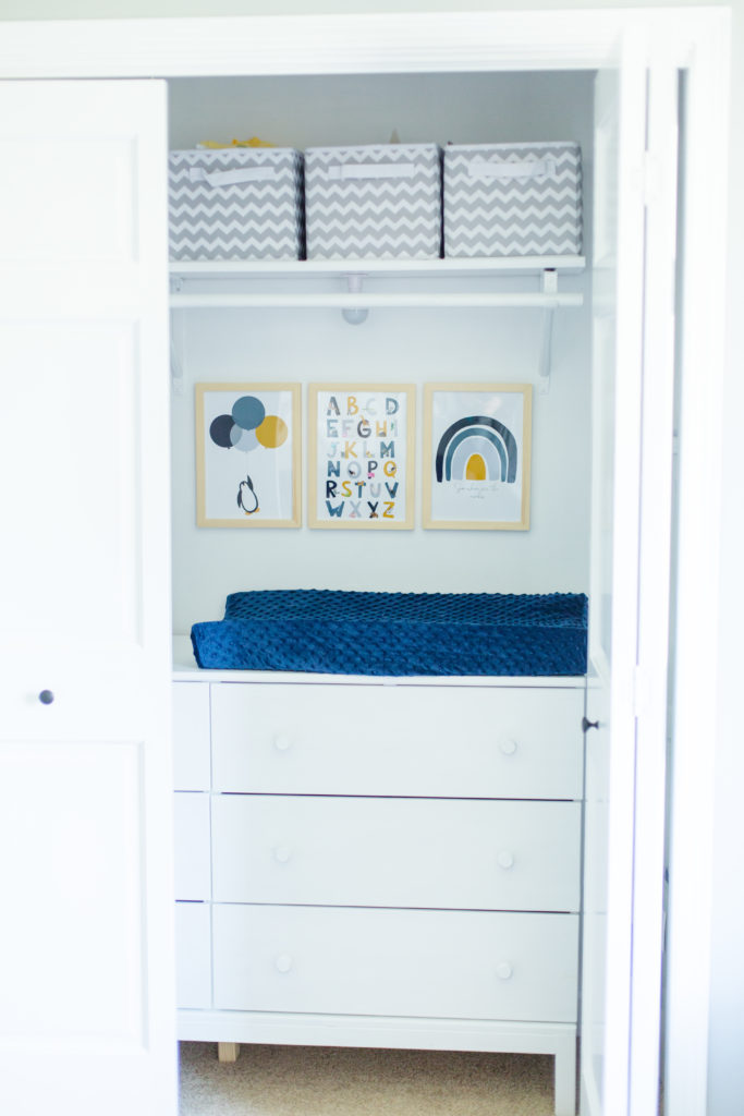 nursery changing table in closet with artwork