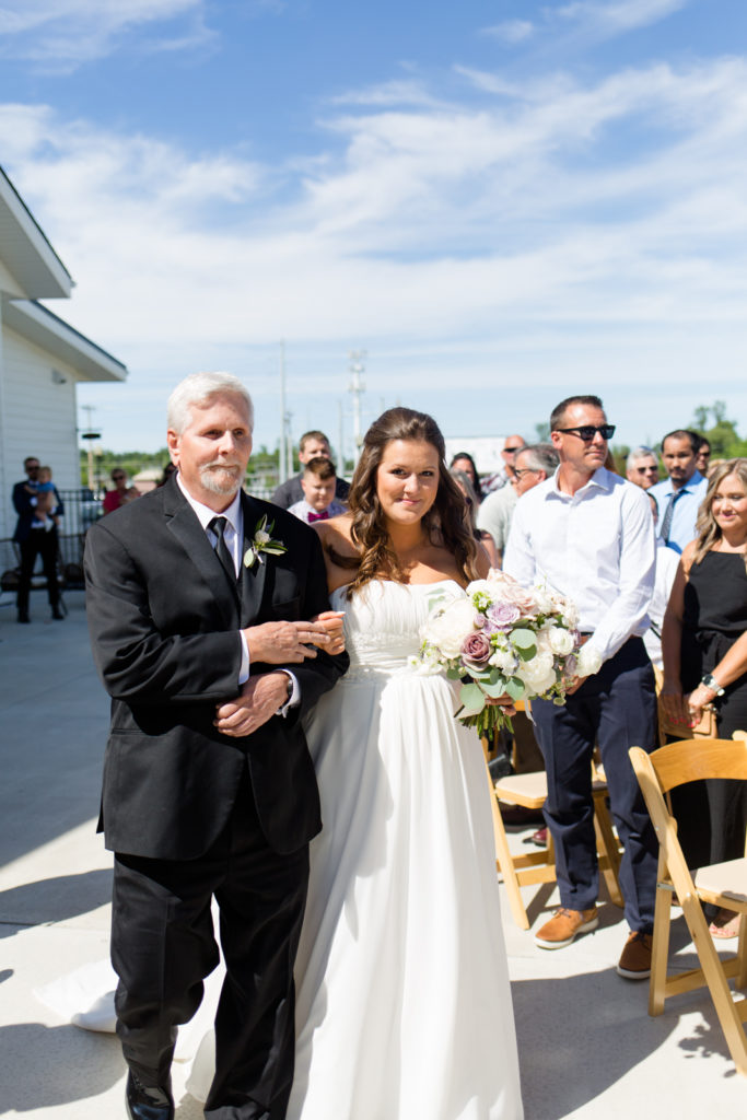 bride walking down aisle with father 