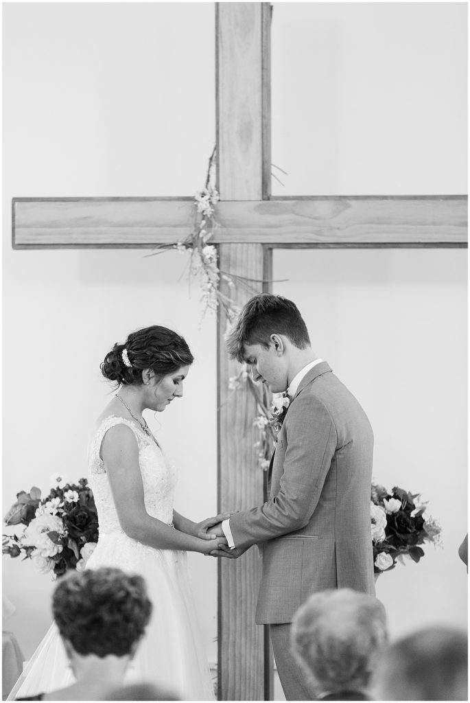 black and white image bride and groom praying moravian chapel heritage hill 